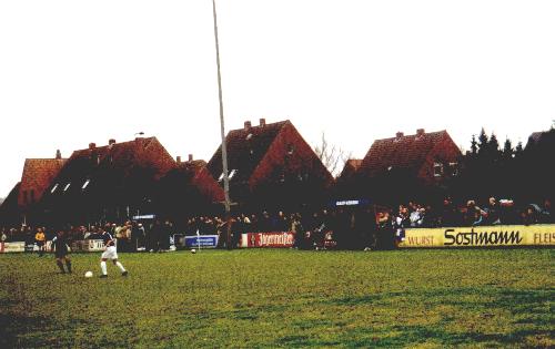 Sportplatz Wiederhall - Leute stehen an einer Wiese